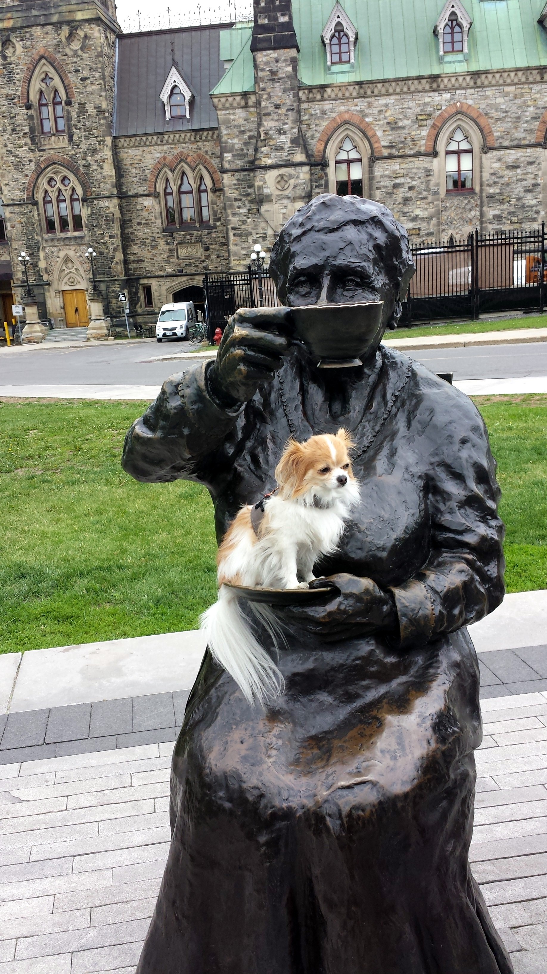 Travel blogger, Montecristo, perched on the saucer of one of the Canadian women's rights heroes portrayed in the statue grouping, The Famous Five, on Parliament Hill, in Ottawa, Canada